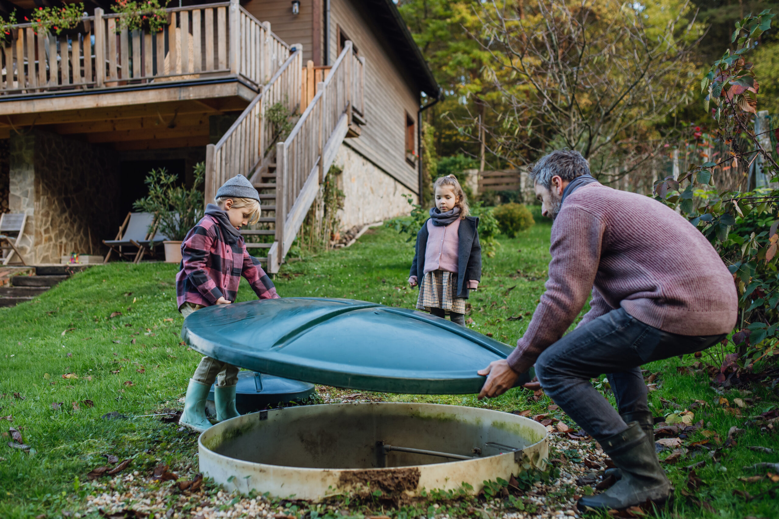 A man checks his wastewater treatment plant as his children look on.